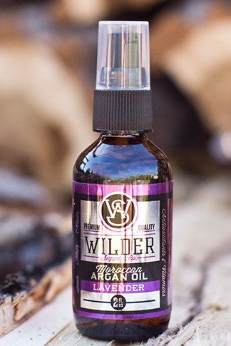Lavender argan oil bottle on wooden surface with nicely blurred background