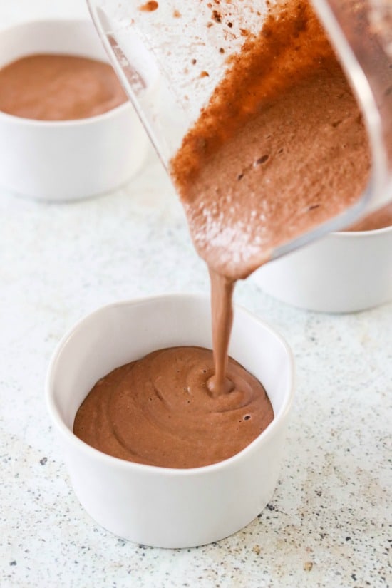 blender pouring chocolate chia seed pudding into bowls