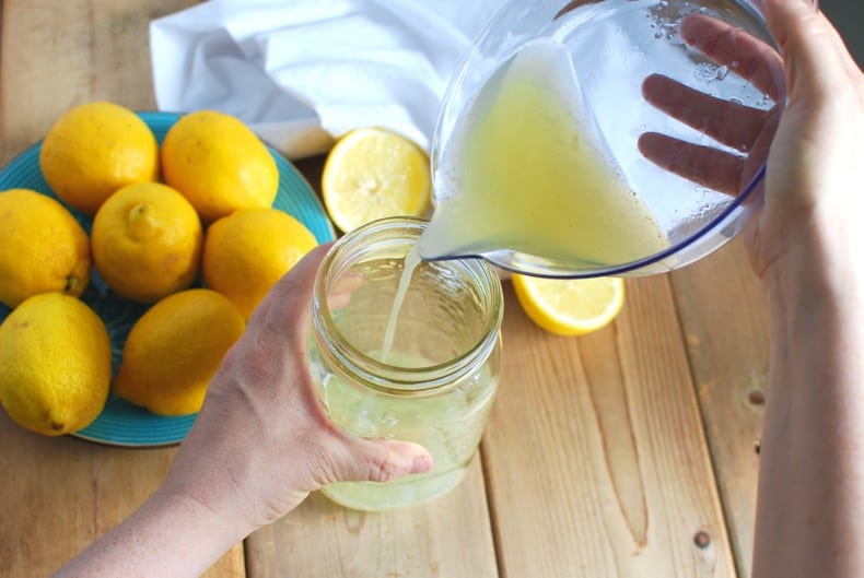 pouring lemon juice into a quart jar