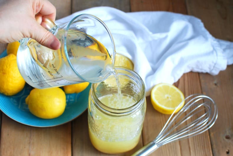 pouring water into a quart jar to make lemonade