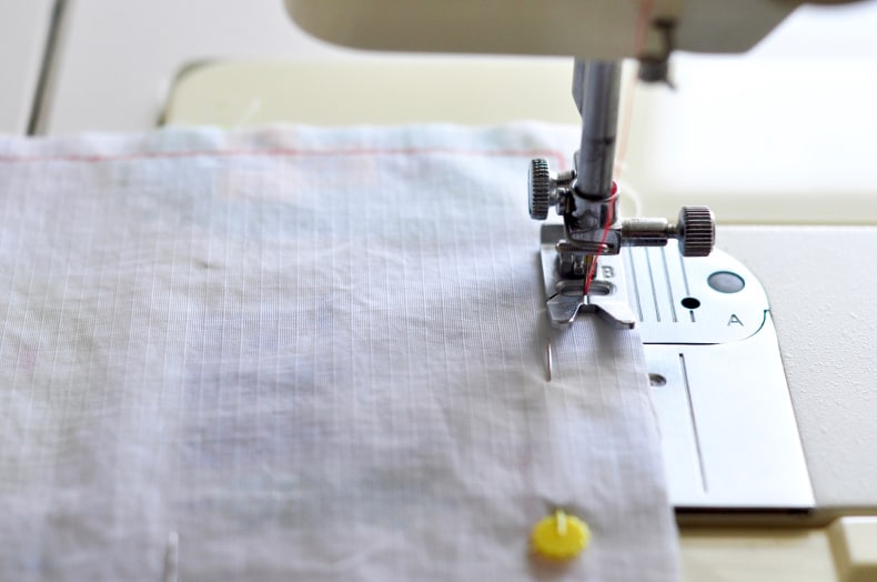 A sewing machine is shown sewing the inner seam for the snack bags.