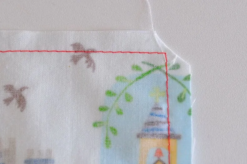The inside of the bag is shown, with red seam stitches all around. The corners have been cut off at a diagonal, carefully to not snip stitches.