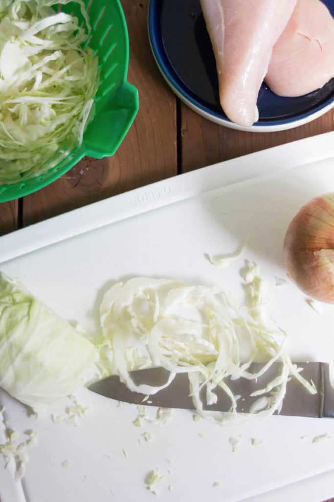 ingredients on a cutting board - cabbage, chicken, etc