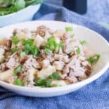 Waldorf Tuna Salad in a white bowl, on top of a blue tea towel.