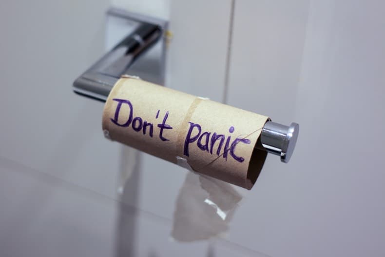 empty roll of toilet paper with the words "don't panic" written on it.