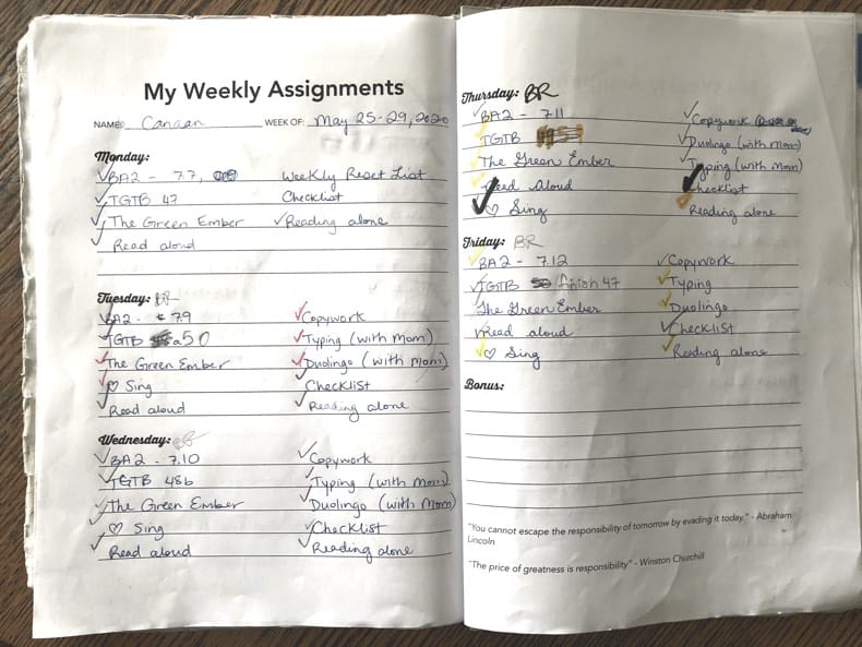 A note book sits open showing the weekly assignments for a 7 year old.