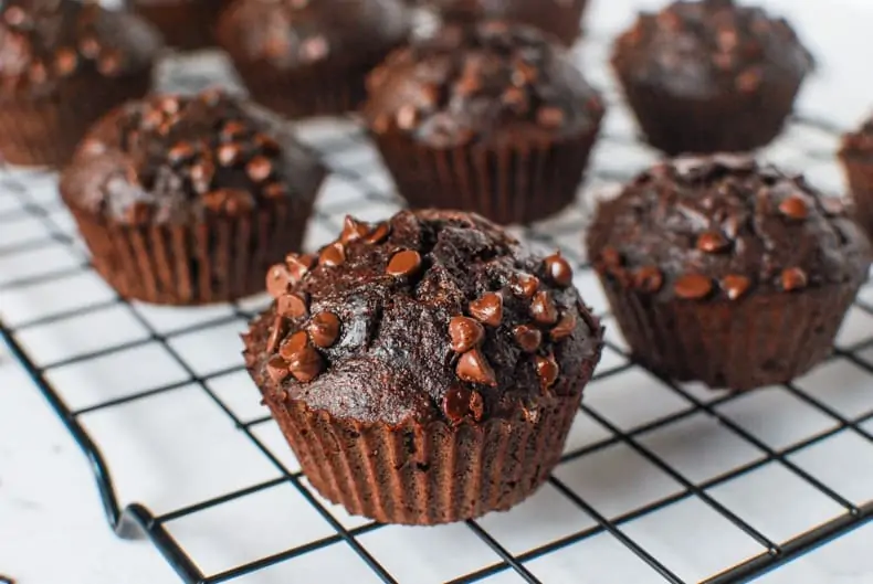 a close up shot of coconut flour chocolate banana muffins on a cooling rack, shot on an angle
