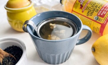 a blue mug with debloating tea with apple cider vinegar, lemon, ginger, and green tea.