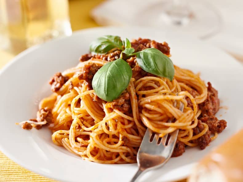 spaghetti in a bowl with basil garnish
