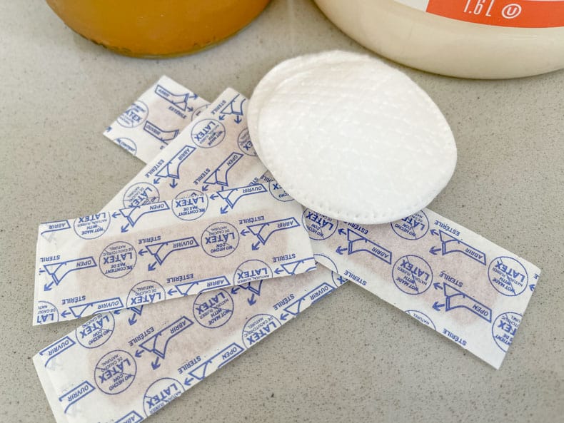 Close up shot of the bandaids and cotton pads to use for DIY wart removal with apple cider vinegar.