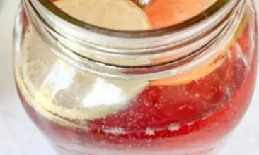overhead shot of a pink sparkling beverage in a mason jar with a stainless steel straw